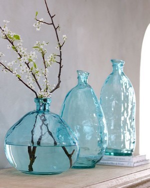 Branche de fruitier en fleur dans un vase bleu transparent